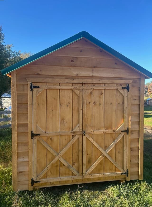Front view of a 2026 storage shed with open double doors